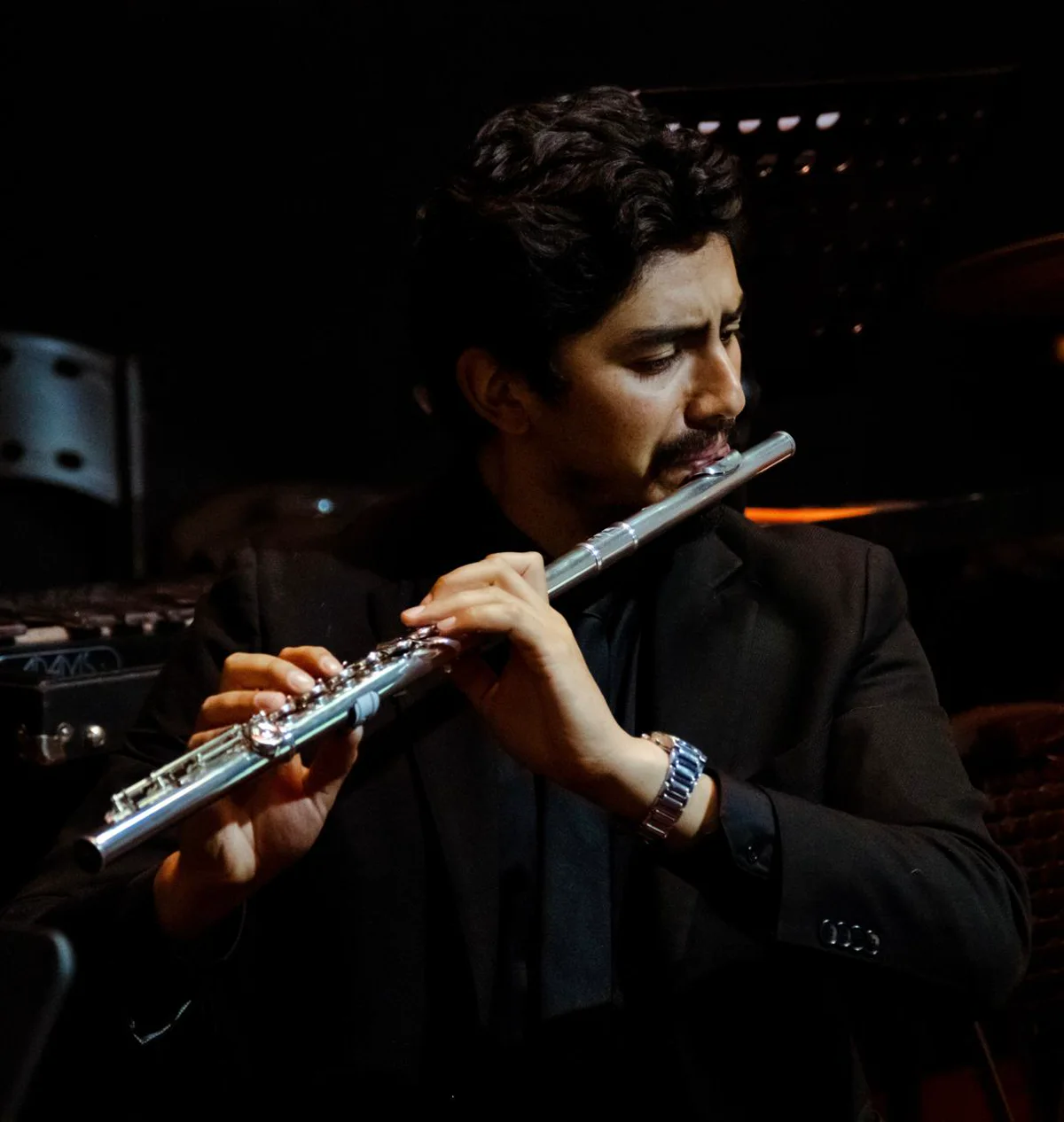 Santiago Ruiz interpretando la flauta bajo luz escénica